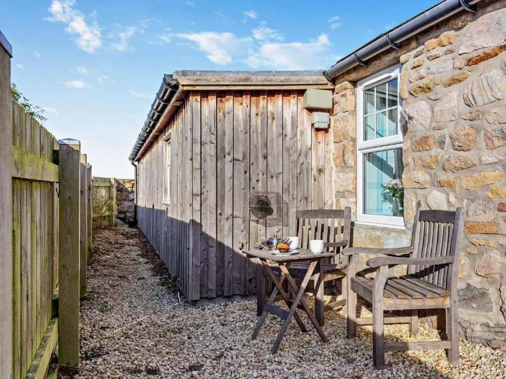 a table and two chairs in front of a building at 1 Bed in Elgin 32129 in Burghead