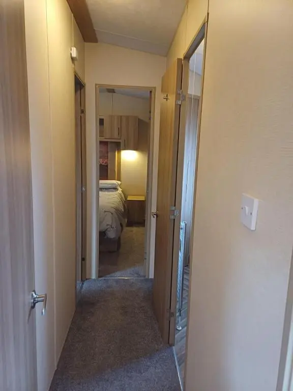 a hallway leading to a bedroom with a bed at The Highlander in Tain