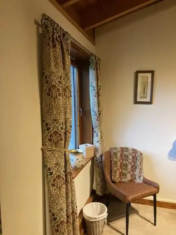 a living room with a chair and a window at Invercassley cottage in Lairg
