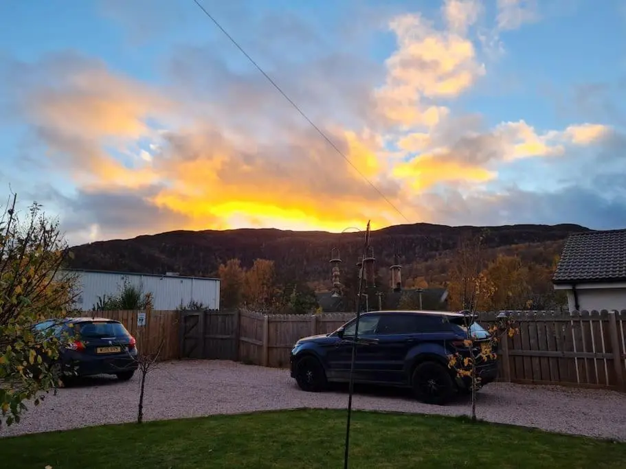 a car parked in a driveway in a yard at Town centre house, Hot tub, Cinema room and Gym in Aviemore