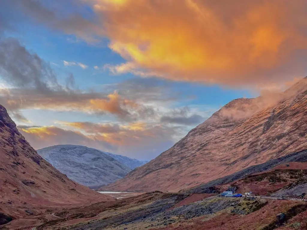 a view of a valley with mountains and a road at Dog friendly cabin & hot tub and Cairngorm views in Aviemore