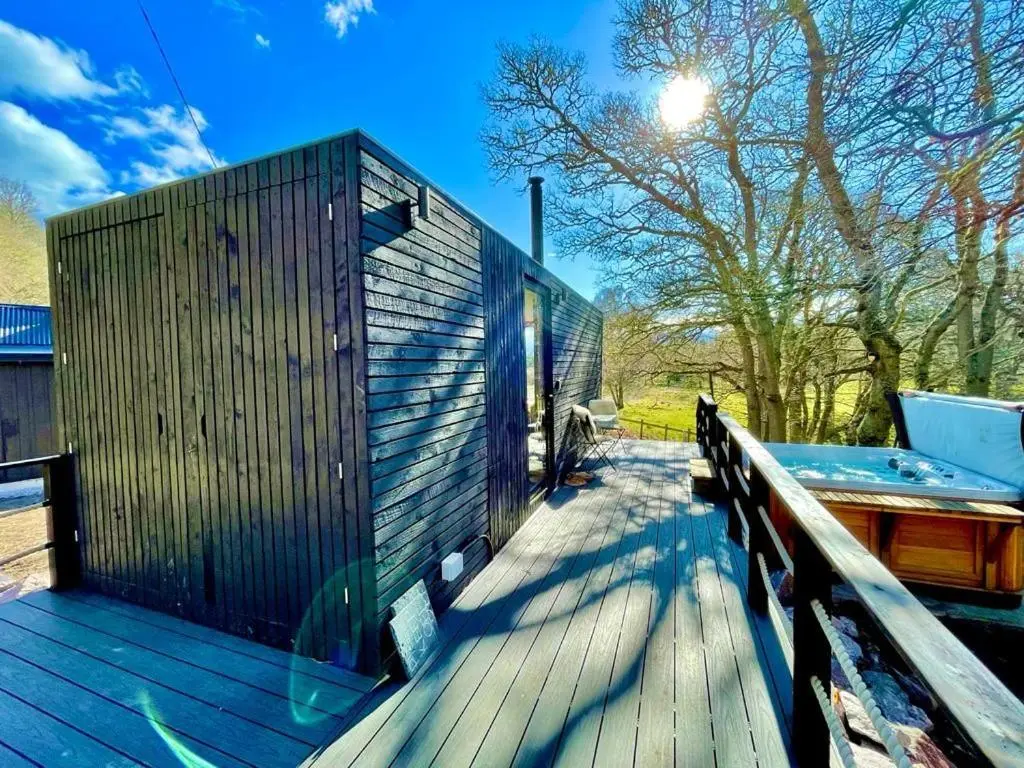 a wooden deck with a wooden fence on it at Dog friendly cabin & hot tub and Cairngorm views in Aviemore