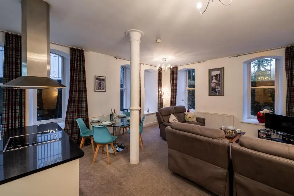 a living room with a couch and a table at Noble Apartment - Highland Club in Fort Augustus