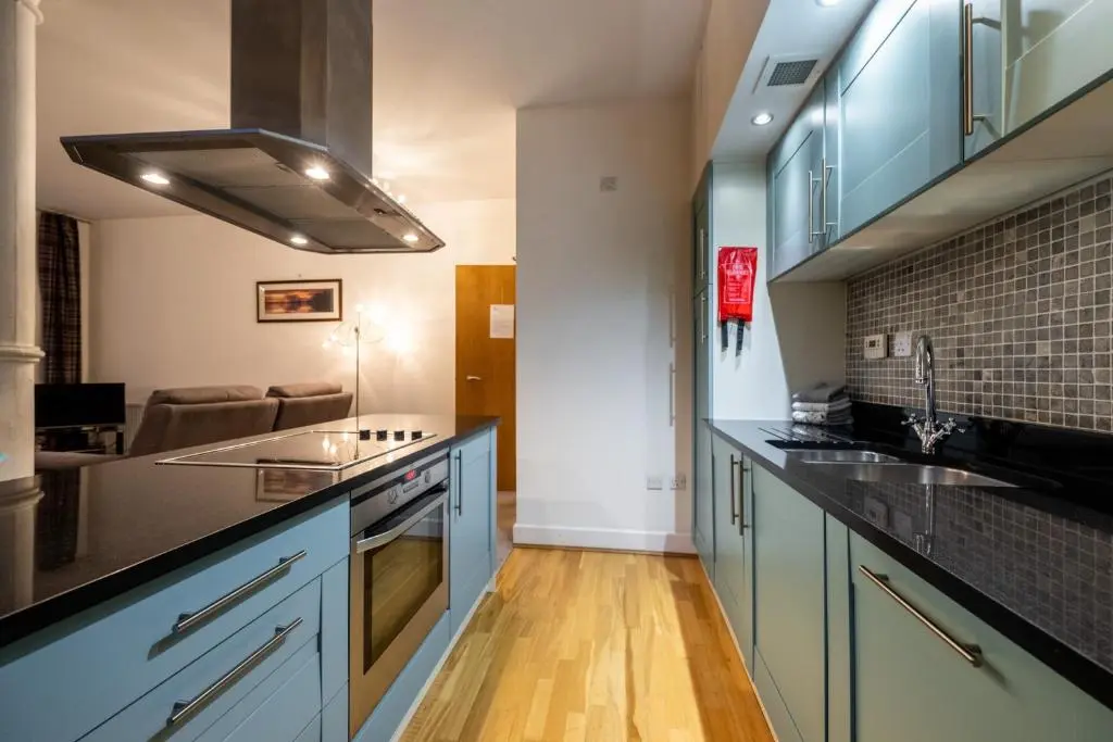 a kitchen with blue cabinets and a counter top at Noble Apartment - Highland Club in Fort Augustus