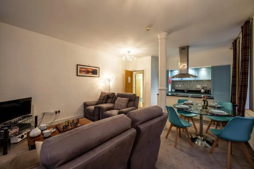 a living room with a couch and a table at Noble Apartment - Highland Club in Fort Augustus