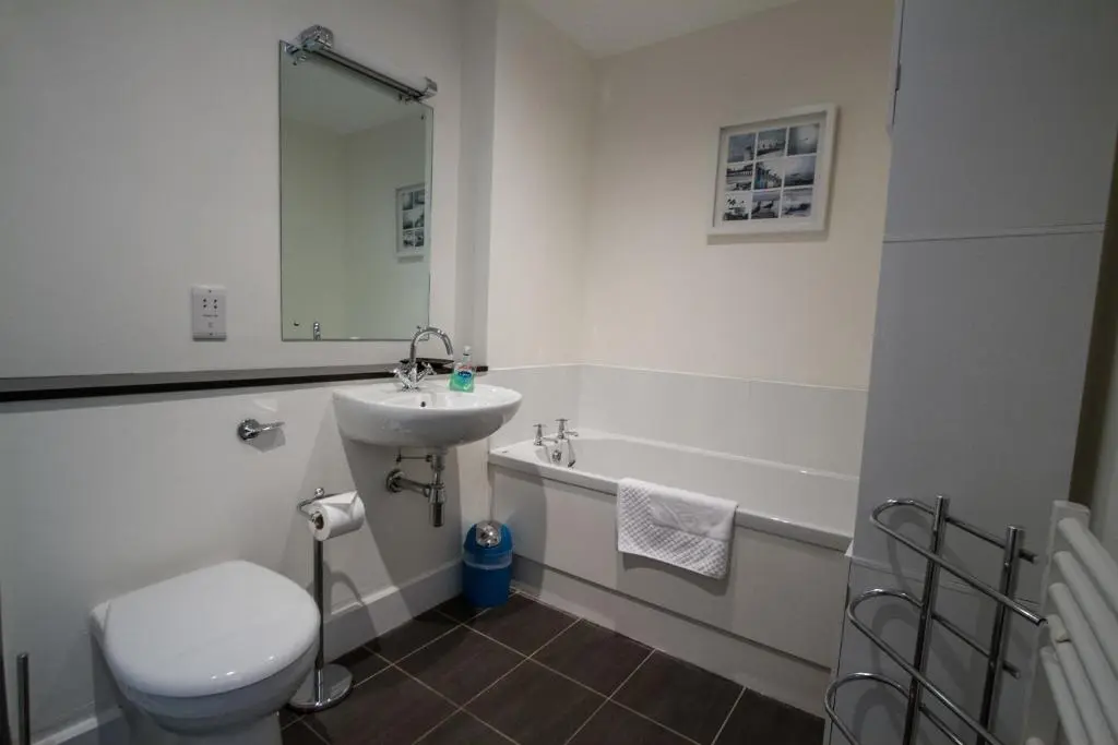 a bathroom with a sink and a toilet and a tub at Noble Apartment - Highland Club in Fort Augustus