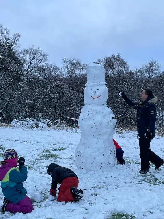 a group of people building a snowman in a field at Drumguish Cottage in Kingussie