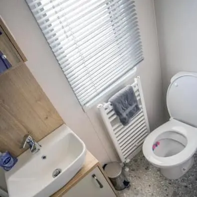 a small bathroom with a toilet and a sink at Robyn\u2019s Nest in Lybster
