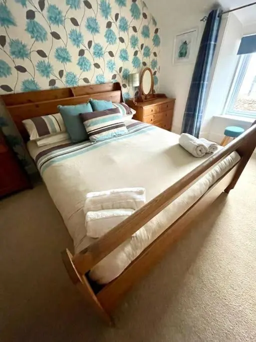 a bedroom with a large bed with towels on it at Comfortable 4 bed Home, Valhalla, Helmsdale in Helmsdale
