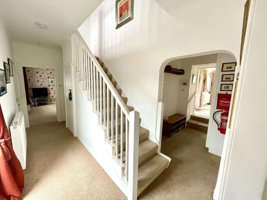 a white staircase in a home with white walls at Comfortable 4 bed Home, Valhalla, Helmsdale in Helmsdale