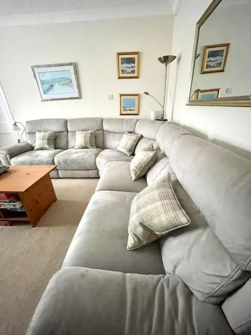 a living room with a gray couch and a table at Comfortable 4 bed Home, Valhalla, Helmsdale in Helmsdale