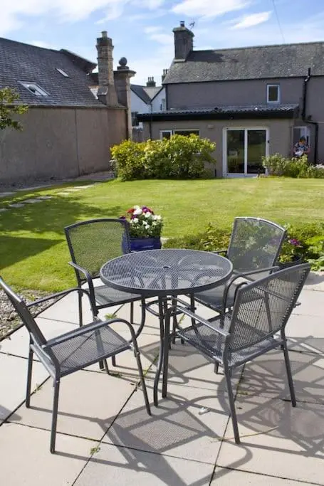 a table and four chairs with a table and a table and chairs at Comfortable 4 bed Home, Valhalla, Helmsdale in Helmsdale
