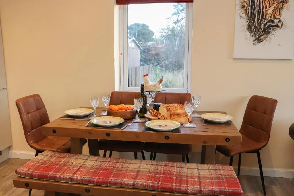 a dining room table with food and a window at Red Squirrel in Dornoch