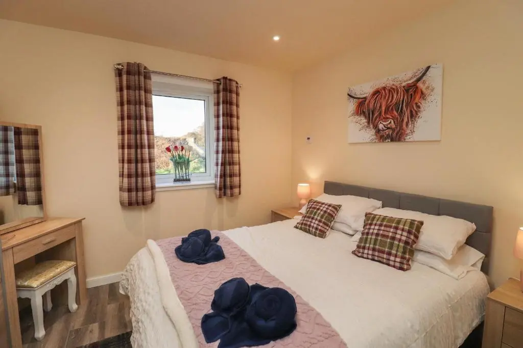 a bedroom with a bed with blue hats on it at Red Squirrel in Dornoch