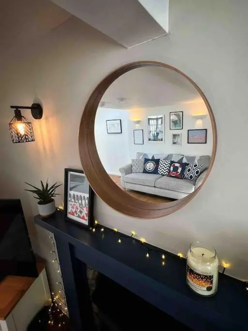 a living room with a mirror and a couch at Cullen Seaside Cottage in Cullen