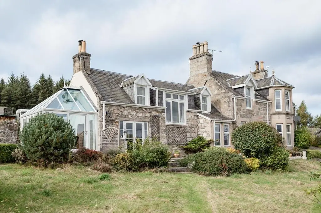 an old stone house with white windows at The Larches in Skye of Curr
