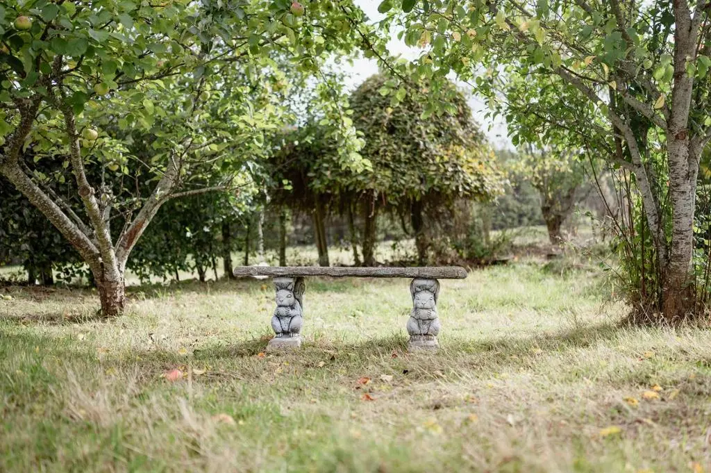 a stone bench sitting in a field with trees at The Larches in Skye of Curr