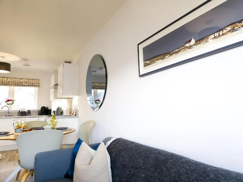 a living room with a couch and a kitchen at 26 Ben Avon in Aviemore