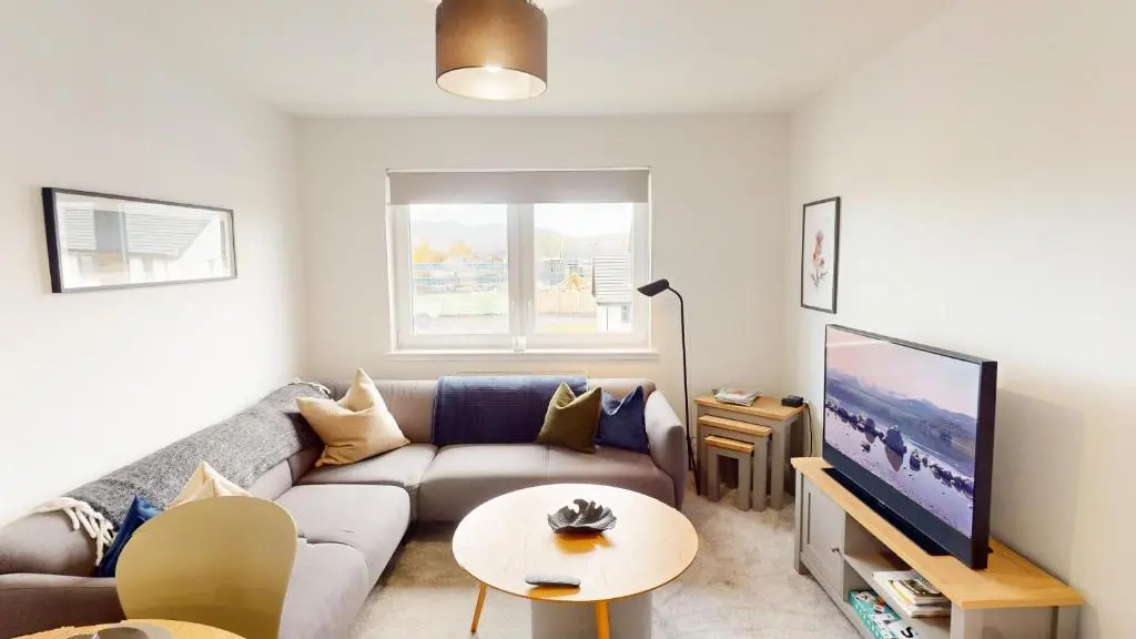 a living room with a couch and a tv at 26 Ben Avon in Aviemore