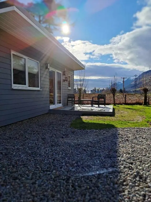 a house with a bench outside of it at Rowan Bank Retreat in Fort Augustus