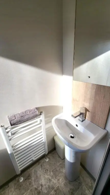a white bathroom with a sink and a mirror at 95 Grantown in Grantown on Spey