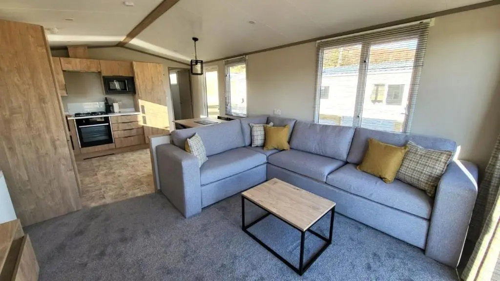 a living room with a blue couch and a table at 95 Grantown in Grantown on Spey