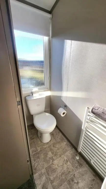 a small bathroom with a toilet and a window at 95 Grantown in Grantown on Spey