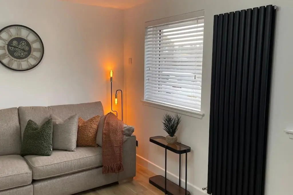 a living room with a couch and a window at Braeview - by Caithness Luxury Apartments NC500 - 3 Bedroom Luxury holiday home - Sleeps Work teams upto 3 & holiday makers upto 5 in Wick
