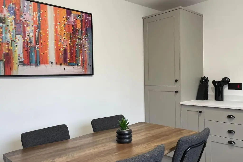 a dining room table with a painting on the wall at Braeview - by Caithness Luxury Apartments NC500 - 3 Bedroom Luxury holiday home - Sleeps Work teams upto 3 & holiday makers upto 5 in Wick