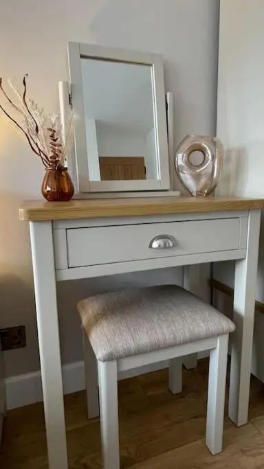 a white dressing table with a mirror and a stool at Braeview - by Caithness Luxury Apartments NC500 - 3 Bedroom Luxury holiday home - Sleeps Work teams upto 3 & holiday makers upto 5 in Wick