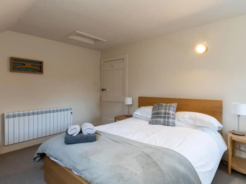 a bedroom with a large bed with towels on it at Holiday Home Railway House by Interhome in Aviemore