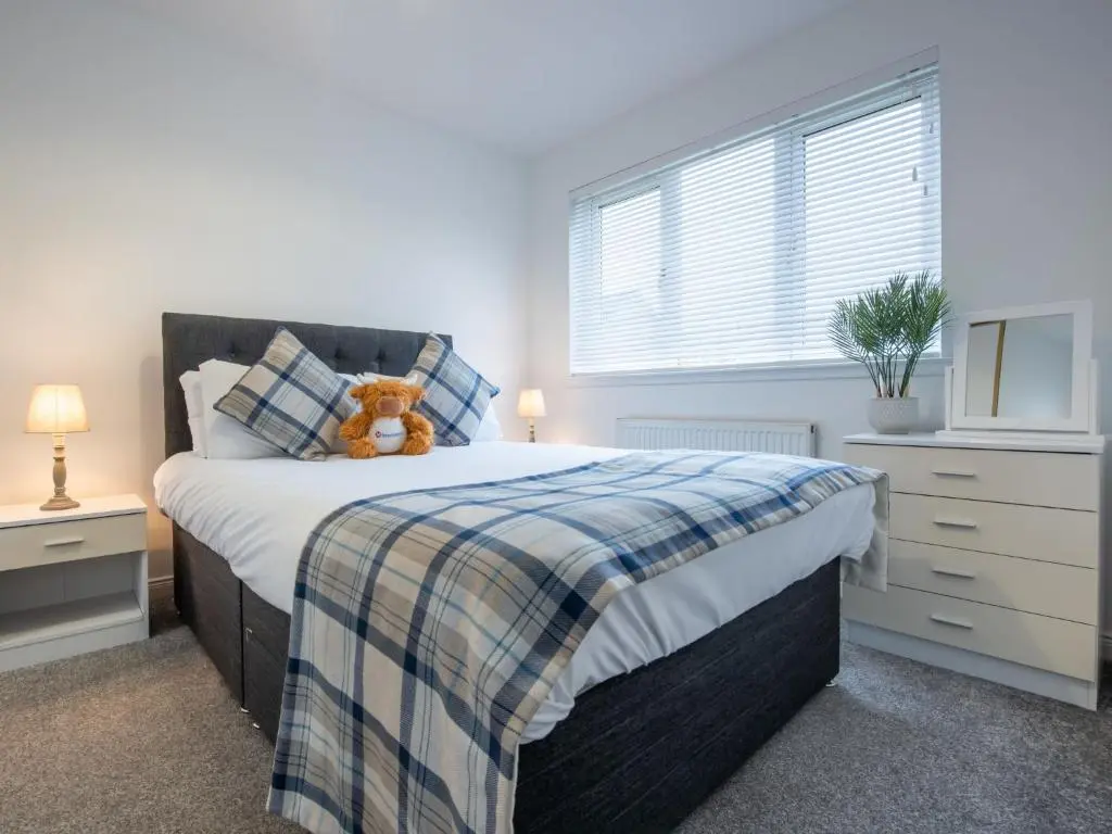 a bedroom with a bed with a teddy bear on it at Apartment Number 39 by Interhome in Inverness