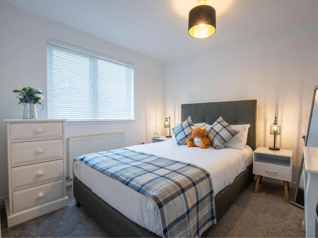 a bedroom with a bed with a teddy bear on it at Apartment Number 39 by Interhome in Inverness