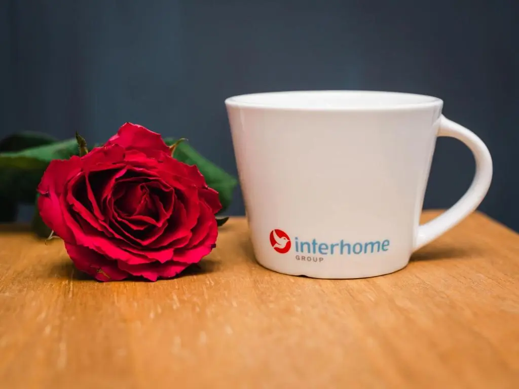 a red rose next to a coffee cup on a table at Apartment Number 39 by Interhome in Inverness