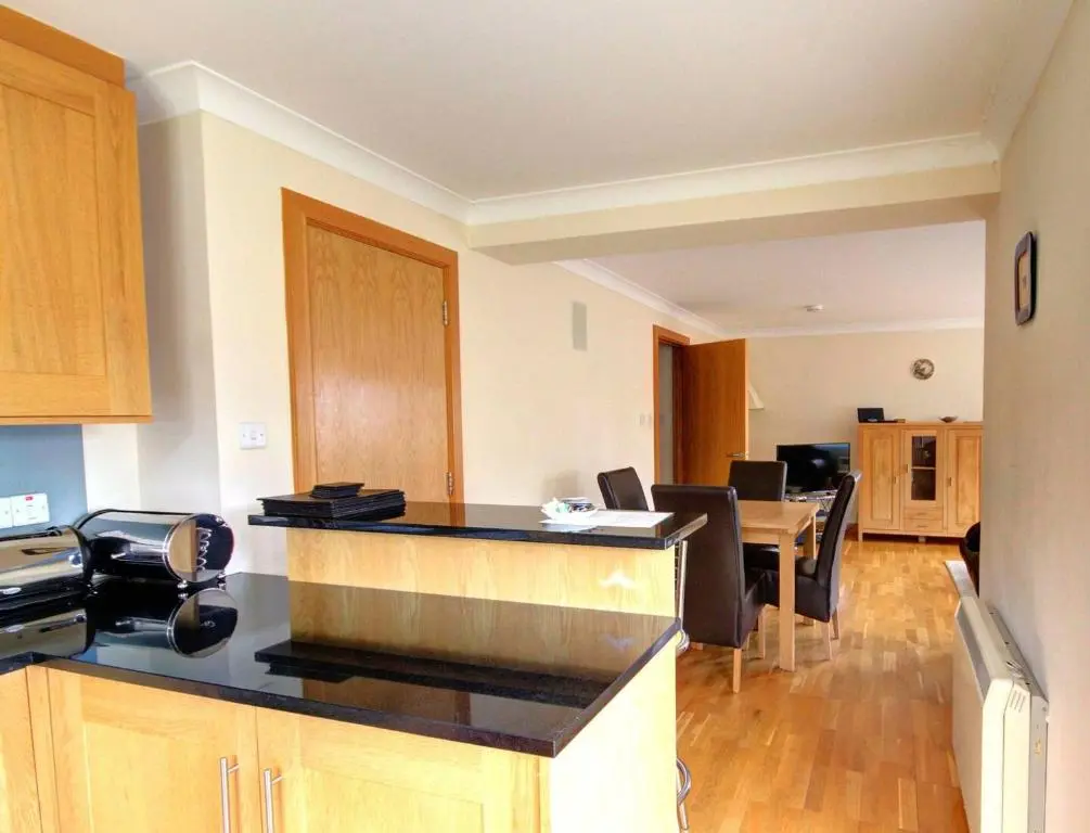 a kitchen with a counter and a dining room at No1 The Links Apartment, Brora in Brora