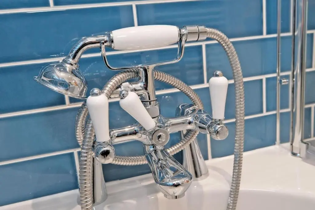 a shower head sitting on top of a sink at Cliff Top Cottage with Sea Views in Portknockie