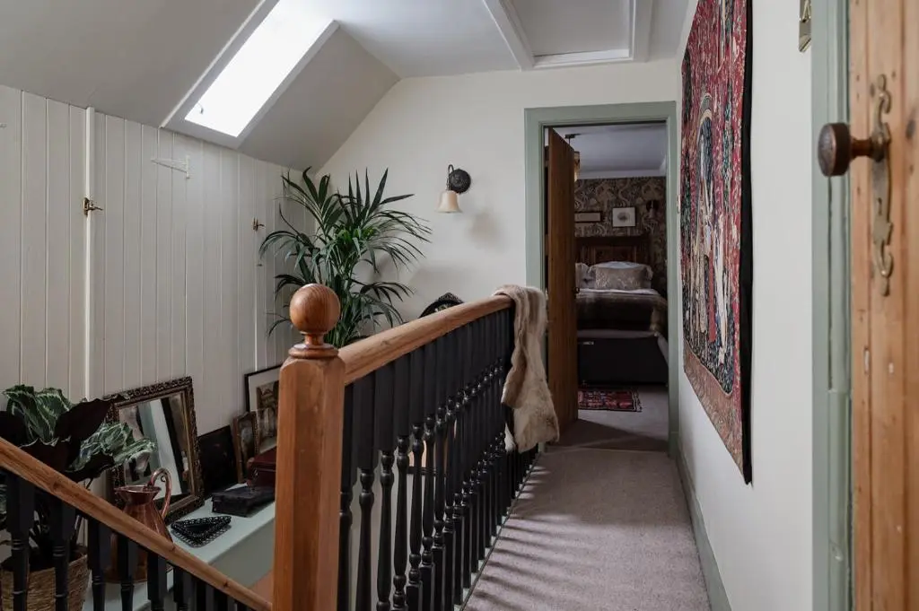 a hallway with a spiral staircase with a stairwayexit at Luxury 3 Bedroom Cottage - Sleeps 6 in Tomintoul