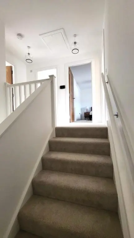 a staircase in a house with white walls at Insch House in Kincraig