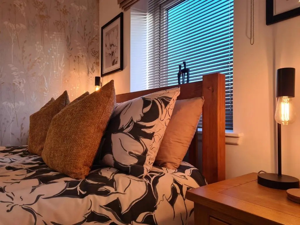 a bedroom with a bed and a table and a window at Findon nook in Culbokie