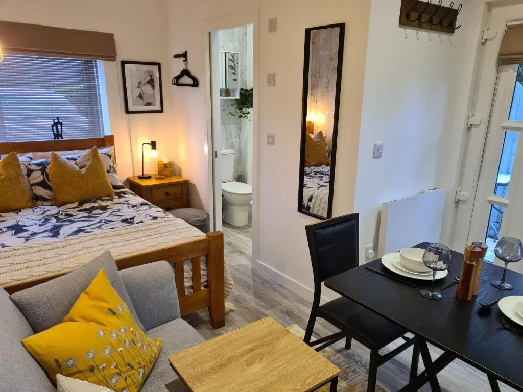 a living room with a bed and a dining room at Findon nook in Culbokie