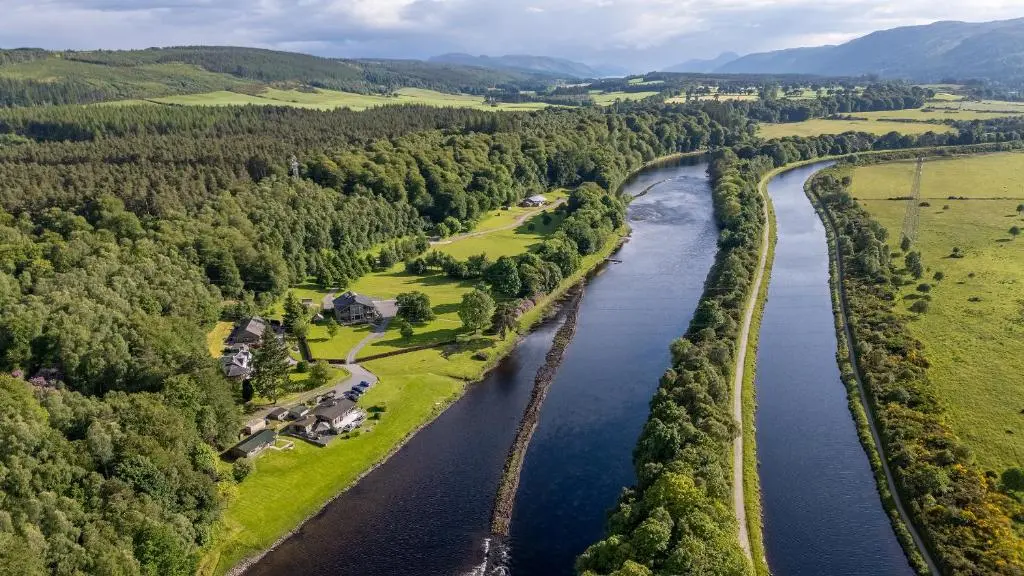 an aerial view of a river with trees at Ness Castle Lodges in Inverness