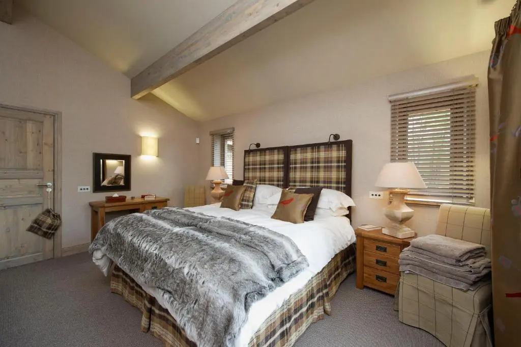 a bedroom with a large bed and two lamps at Ness Castle Lodges in Inverness