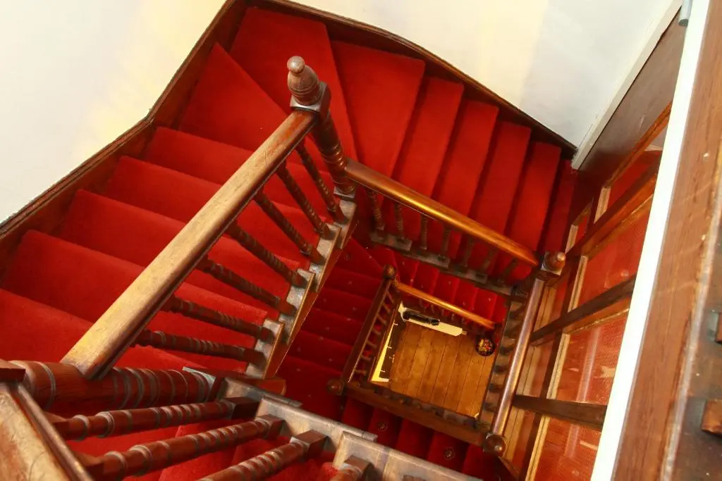 an overhead view of a staircase with red carpet at The Retreat Hotel in Strathpeffer