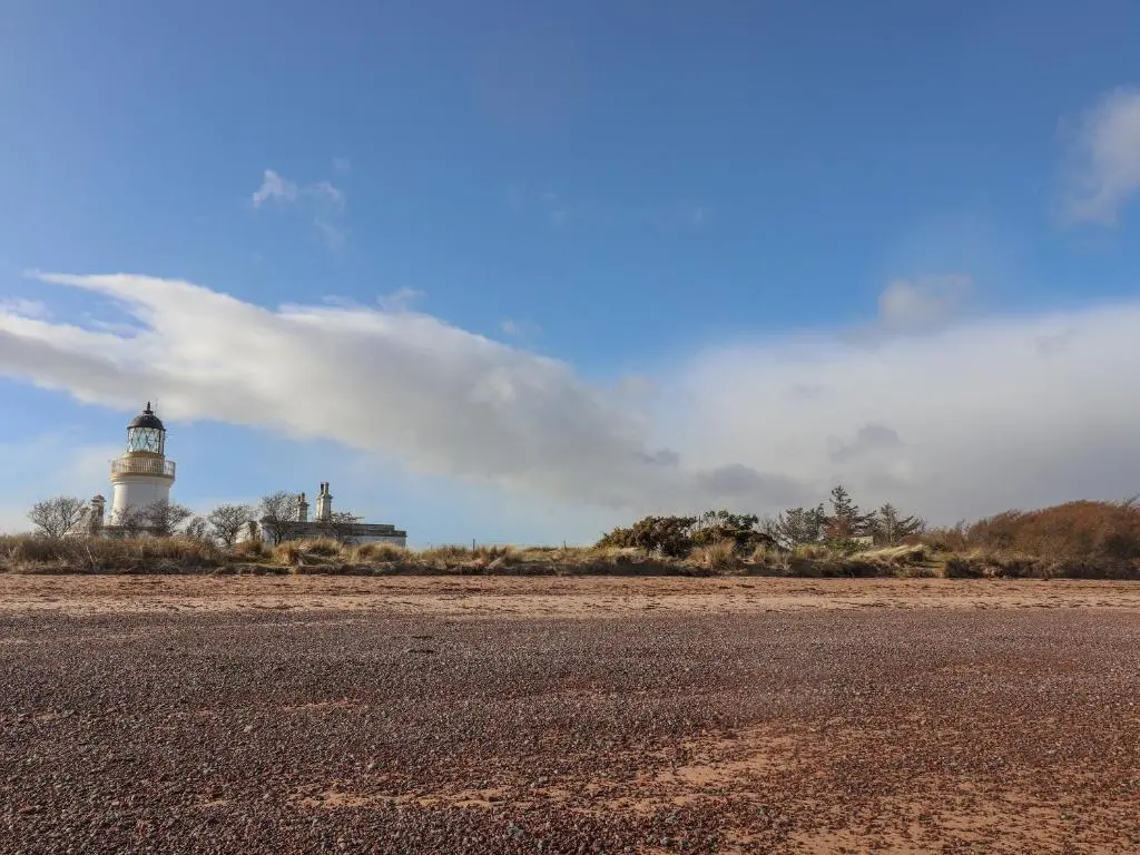a lighthouse sitting on the side of a dirt road at Reyflat Barn in Fortrose