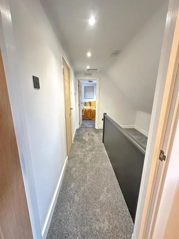 a hallway with a staircase in a house at Smiddy Cottage Bauds in Buckie