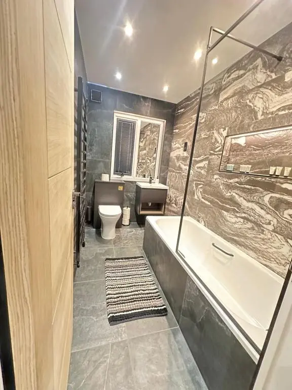 a bathroom with a tub and a sink and a toilet at Smiddy Cottage Bauds in Buckie