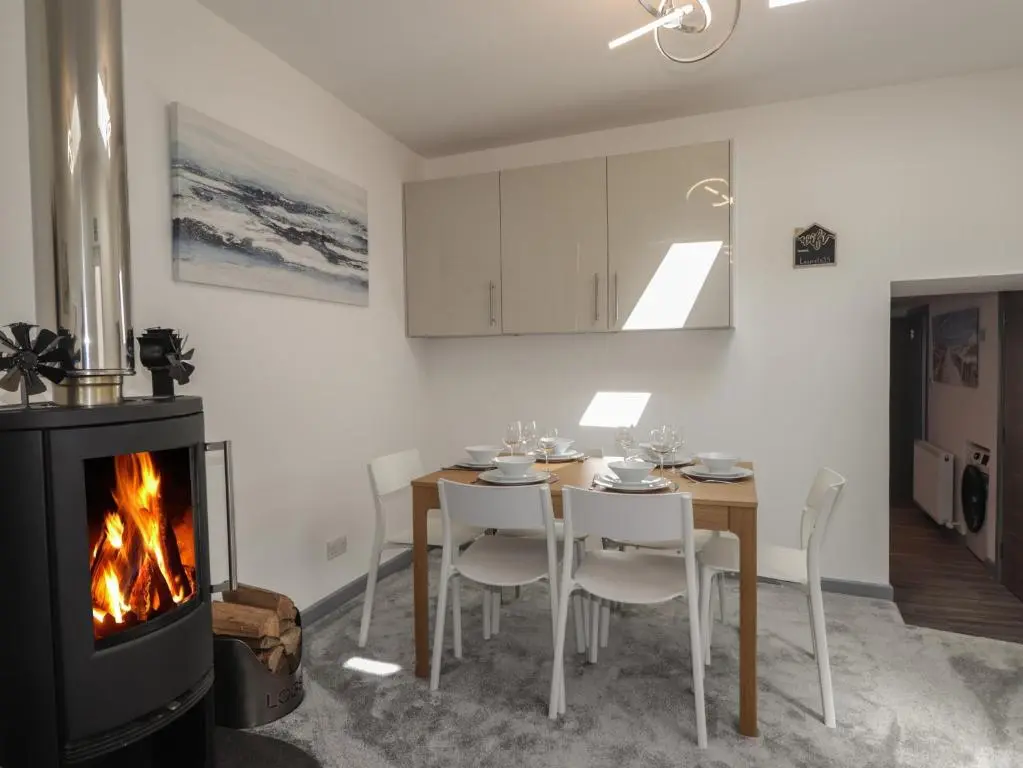 a dining room with a table and a fireplace at The Laurels in Fraserburgh