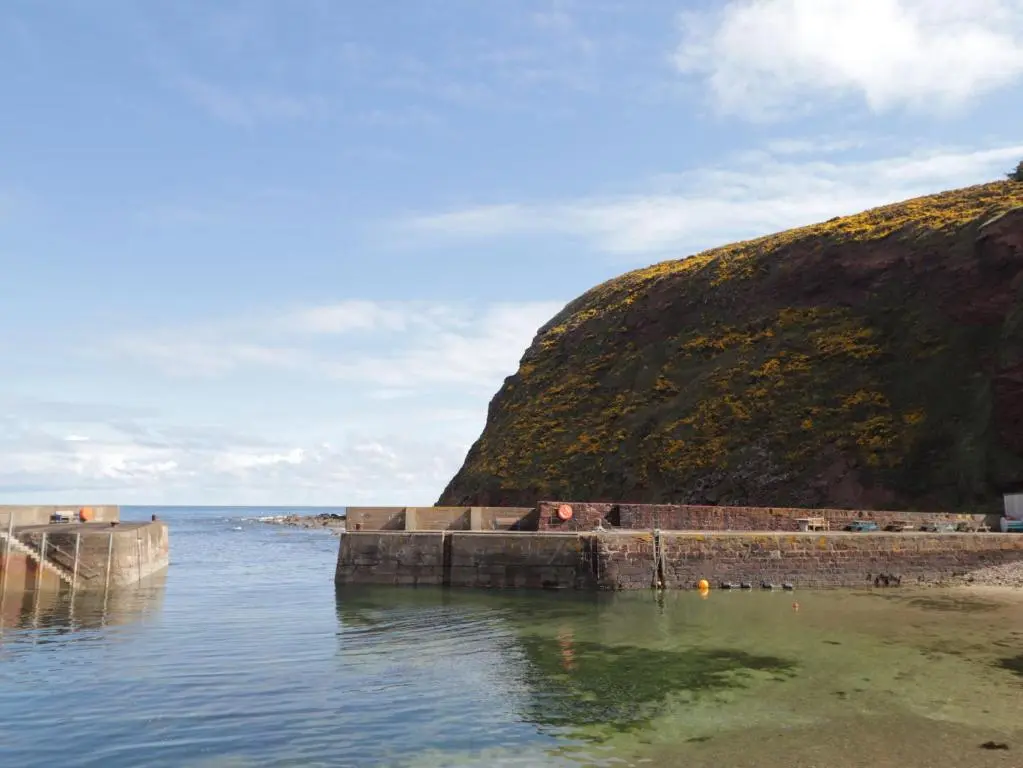 a body of water next to a large hill at The Laurels in Fraserburgh
