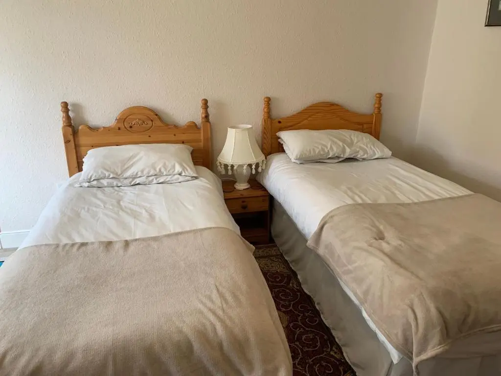 two beds sitting next to each other in a room at Loubcroy Farm House in Lairg