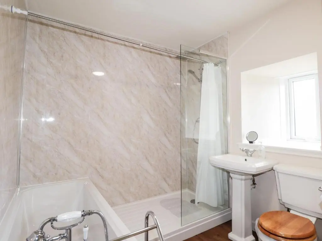 a bathroom with a shower and a toilet and a sink at Loubcroy Farm House in Lairg